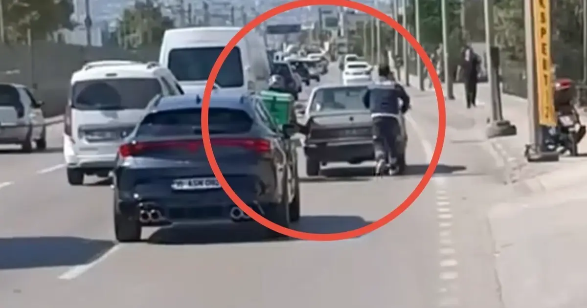 Bursa'da motokuryeden arızalanan otomobili itmek için ilginç yöntem